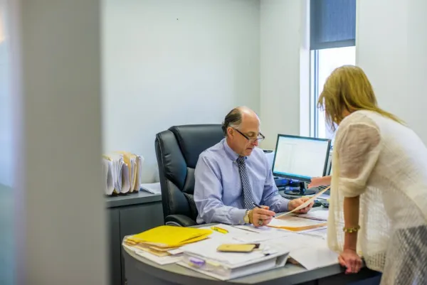 senior-man-discussing-paperwork-with-office-worker-2025-04-04-08-28-51-utc1-684df3c1bf48b